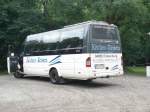Ein kleinbus der Firma Kcher-Reisen steht auf einem Parkplatz in Falkenhain
