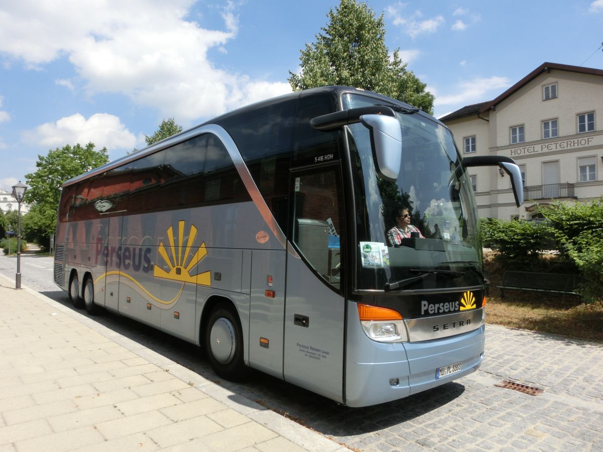 Setra S 416 HDH der '100 Jahre Otto Kässbohrer Edition' von Perseus-Reisen aus Neumarkt-St. Veit. Anlässlich des 100. Geburtstags von Otto Kässbohrer gab es ab 2003 eine auf 100 Exemplare limitierte Sonderserie der Setra TopClass 400. Dieses Fahrzeug wurde 2003 gebaut und ist mit 50+1 Schlafsesseln vom Modell 'Top' in Ambiente-Polsterung mit Lederkopfteil (in der üblichen 2-2-Bestuhlung das Topmodell) sowie natürlich mit Bordküche und Toilette ausgestattet. Als Antrieb dient ein V8 Typ MB OM 502 LA mit 350 kW (476 PS) (Leistung per Chiptuning gesteigert) und das automatisierte Zwölfgang-Schaltgetriebe ZF 12 AS 2300 B.
Bis 2012 gab es bei Perseus einen weiteren, identischen S 416 HDH.
Diese Aufnahme entstand am 15. 7. 2015 vor dem Bahnhof in Neumarkt-St. Veit, als der Reisebus gerade eine Tour auf der RBO-Linie 7517 gefahren war.